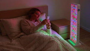 Woman relaxing under Aura Sweden Quantum500 red light therapy panel